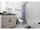 Bathroom with a white vanity, granite countertop, and a shower-tub with a blue shower curtain at 2591 Seagirt Way, Clermont, FL 34711