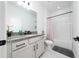 Bright bathroom featuring a vanity with granite countertops, white cabinets, and a shower-tub combo at 2591 Seagirt Way, Clermont, FL 34711