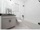 Modern bathroom with a tub/shower combo, granite countertop, and sleek white tile at 2591 Seagirt Way, Clermont, FL 34711