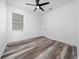 Bright bedroom features a modern ceiling fan, a window and stylish wood-look flooring at 2591 Seagirt Way, Clermont, FL 34711