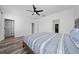 Bright bedroom features a ceiling fan, wood floors, and blue and white striped bedding at 2591 Seagirt Way, Clermont, FL 34711