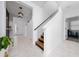 Inviting foyer featuring a staircase, modern lighting, and sleek tile flooring at 2591 Seagirt Way, Clermont, FL 34711