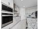 Modern kitchen features stainless steel appliances, white cabinets, and granite countertops at 2591 Seagirt Way, Clermont, FL 34711