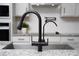 Close-up of a modern faucet and sink with granite countertop details at 2591 Seagirt Way, Clermont, FL 34711