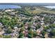 An aerial view shows a home surrounded by lush trees in a neighborhood near a body of water at 2623 Gables Dr, Eustis, FL 32726