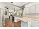 Bright kitchen featuring white cabinets, stainless steel appliances, and wood-look floors, offering a modern design at 2623 Gables Dr, Eustis, FL 32726