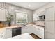 Well-lit kitchen with white cabinets, stainless steel appliances, modern fixtures, and decorative wallpaper at 2623 Gables Dr, Eustis, FL 32726