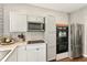 Kitchen with stainless steel appliances, white cabinets, and ample counter space, perfect for cooking and entertaining at 2623 Gables Dr, Eustis, FL 32726