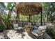 Outdoor patio with tiki umbrella, outdoor furniture, and fire pit at 2623 Gables Dr, Eustis, FL 32726