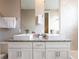 Modern bathroom featuring double sinks with granite countertop and decorative mirrors at 2660 Sunrise Shores Dr, Kissimmee, FL 34747