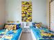 Whimsical bedroom featuring two twin beds with Minion-themed decor and light blue walls at 2660 Sunrise Shores Dr, Kissimmee, FL 34747