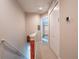 Upstairs hallway featuring neutral walls, carpet and an entrance into a room with light streaming through the window at 2660 Sunrise Shores Dr, Kissimmee, FL 34747