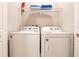 Efficient laundry room with white washer and dryer, plus storage shelves at 2660 Sunrise Shores Dr, Kissimmee, FL 34747