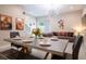 Open-concept living area featuring a modern chandelier, comfortable sofa, and themed artwork at 2660 Sunrise Shores Dr, Kissimmee, FL 34747