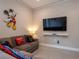 Cozy living room featuring a sectional sofa, large screen television, and kid-friendly decor at 2660 Sunrise Shores Dr, Kissimmee, FL 34747