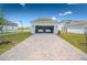 Two-car garage with a paved driveway in front of a well-maintained home at 3027 Addison Blvd, St Cloud, FL 34771