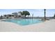 Large community pool with plenty of seating and a clubhouse in the background on a sunny day at 3027 Addison Blvd, St Cloud, FL 34771