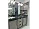 Modern bathroom featuring a double vanity with dark countertops and gray wood-look cabinets, plus storage at 3082 Se 140Th Ln, Summerfield, FL 34491