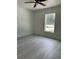 Minimalist bedroom with luxury vinyl flooring, ceiling fan, and a window showcasing the exterior view at 3082 Se 140Th Ln, Summerfield, FL 34491