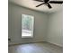 Neutral bedroom with luxury vinyl flooring, ceiling fan, and a window showcasing the exterior view at 3082 Se 140Th Ln, Summerfield, FL 34491