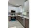 Modern kitchen with stainless steel appliances, grey backsplash, and stylish white and gray cabinets at 3082 Se 140Th Ln, Summerfield, FL 34491