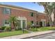 View of a brick townhouse featuring lush landscaping, green shutters, and classic architectural details at 316 Georgetown Dr # 316, Casselberry, FL 32707