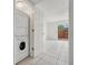 Bright laundry room features a stacked washer and dryer and tile floor; doorway to fenced back yard at 316 Georgetown Dr # 316, Casselberry, FL 32707