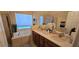Bright bathroom featuring a large soaking tub, dual vanities, and large mirror at 4102 Feldspar Trl, Orlando, FL 32826