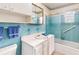 Retro bathroom featuring blue tile, a shower-tub and a vanity with storage at 413 5Th S St, Dundee, FL 33838