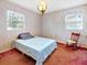 Bright bedroom featuring vintage wallpaper, two windows and a hanging vintage light fixture at 413 5Th S St, Dundee, FL 33838