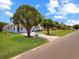 Well-maintained front yard with mature trees and landscaping leading to charming home at 413 5Th S St, Dundee, FL 33838