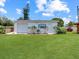 A one-car garage with a yard featuring garden bed with colorful flowers and luscious green grass at 413 5Th S St, Dundee, FL 33838