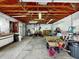 Spacious garage interior with exposed beams, fluorescent lighting, and ample storage space at 413 5Th S St, Dundee, FL 33838