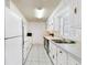 Galley kitchen featuring white cabinets, tile floors, and stainless steel appliances at 413 5Th S St, Dundee, FL 33838