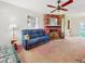 Cozy living room featuring a brick fireplace, wood paneling, and a comfortable sofa at 413 5Th S St, Dundee, FL 33838