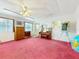 Bright, spacious living room featuring pink carpet, ceiling fan, and piano at 413 5Th S St, Dundee, FL 33838