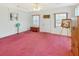 Spacious living room with pink carpet, natural light, and front door at 413 5Th S St, Dundee, FL 33838