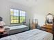 Bright bedroom featuring two beds, vintage furnishings, and a large window with views of lush greenery at 502 Canopy Ln, Lady Lake, FL 32159