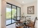 Elegant dining area with glass table and view of the outdoor patio and lush backyard at 502 Canopy Ln, Lady Lake, FL 32159