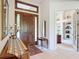 Welcoming foyer featuring a wooden door, stylish mirror, and glimpse into a bright and airy room at 502 Canopy Ln, Lady Lake, FL 32159