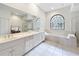 Main bathroom features dual sinks, a soaking tub, and a glass shower at 502 Canopy Ln, Lady Lake, FL 32159