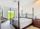 Main bedroom with large four-poster bed and a view of the backyard at 502 Canopy Ln, Lady Lake, FL 32159