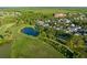 Aerial perspective of a residential community adjacent to a well-maintained golf course and a tranquil pond at 506 Golfpark Dr, Celebration, FL 34747