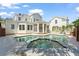 An expansive backyard with a uniquely shaped pool and spa, surrounded by a large white house with ample windows at 506 Golfpark Dr, Celebration, FL 34747