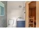 Bathroom with tiled wall, blue vanity, and adjacent wood-paneled sauna with built-in benches and starry ceiling at 506 Golfpark Dr, Celebration, FL 34747