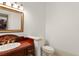 Cozy half bathroom featuring a wooden vanity and a white toilet at 506 Golfpark Dr, Celebration, FL 34747