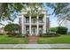 Elegant brick home with prominent white columns, black shuttered windows, and manicured lawn at 506 Golfpark Dr, Celebration, FL 34747
