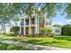 Stately brick home with white columns, black shutters, and lush landscaping at 506 Golfpark Dr, Celebration, FL 34747
