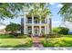 Stately two-story brick home with grand columns, a welcoming front porch, and meticulously manicured landscaping at 506 Golfpark Dr, Celebration, FL 34747