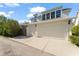 Spacious three-car garage with white doors, complemented by an extended driveway and well-maintained landscaping at 506 Golfpark Dr, Celebration, FL 34747